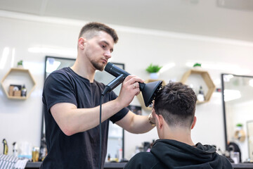 Professional Barber Finishing Haircut with Blow Dry at Local Small Business Barbershop.  Barber...