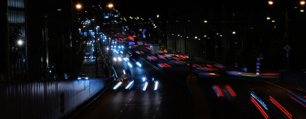 Night city traffic on a highway with vibrant light trails from moving vehicles, capturing dynamic...