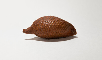 Salak (Salacca zalacca) is a species of palm tree (family Arecaceae), snake fruit or snakeskin fruit due. One fruit on a white background.