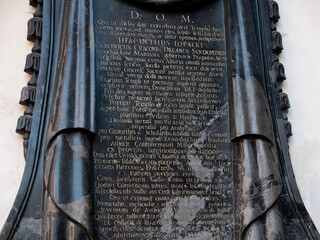 Latin epitaph inscription carved in a large tall black marble plaque with gold letters on a church...