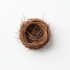 Obraz premium A close-up image of an empty bird's nest made of intertwined twigs on a plain white background.