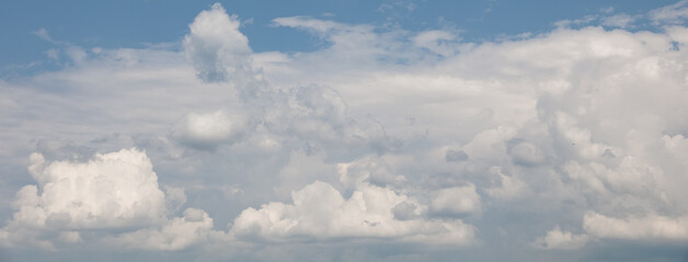 Beautiful white cumulus clouds are forming in a bright blue sky, creating a peaceful and serene atmosphere, perfect for backgrounds and nature-themed projects