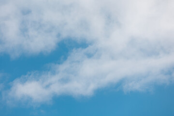 Beautiful white clouds are gently drifting across a vibrant blue sky, creating a serene and...