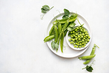 Fresh green peas in a white plate, healthy snack, copy space