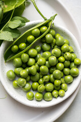 Close-up fresh green peas beans in a white plate