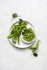 Fresh green peas in a white plate, healthy snack, copy space