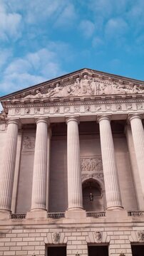 Vertical time-lapse of clouds passing over the south pediment of the William Jefferson Clinton Federal Building, headquarters of the US Environmental Protection Agency. The camera pans left to right.
