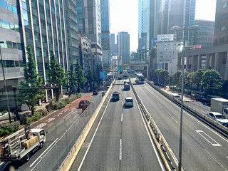 City street with white sky horizon with business building landscape background and cars on a bright sunny day in Shibuya Japan