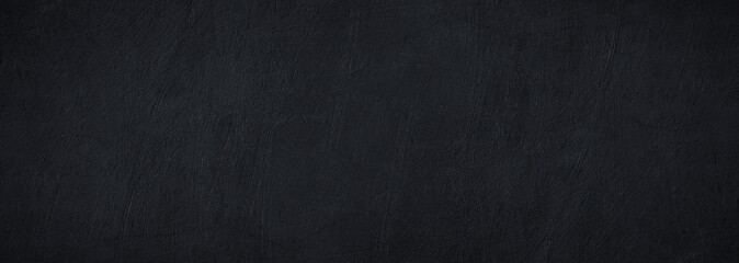Black dark surface background of concrete wall. Cement plaster. Rough grunge. Wide banner. Panoramic. Design.