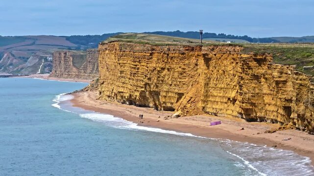 Telephoto aerial shot of the yellow cliffs at Hive Beach on the Jurassic coast of Dorset, UK