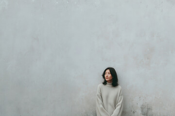 minimalistic portrait of person standing against ancient textured wall