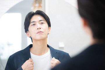A man checking his morning appearance in front of the washbasin mirror.