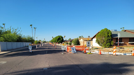 City street with road signs marking dangerous construction area and guiding drivers to keep in...