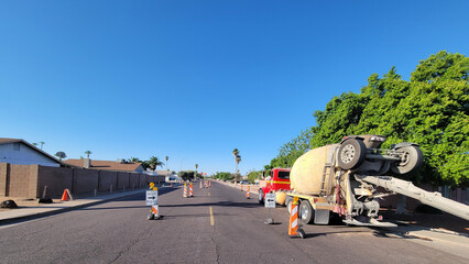Safety corridor in the middle of city street marked by road signs and a parked concrete mixer truck...