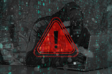 A hooded hacker behind a laptop with a red glowing warning with a triangle and exclamation mark. Binary code overlays the scene, emphasizing the concept of data leakage and cybercrime.