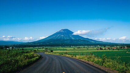 Fototapeta premium Winding Road Leading to Majestic Volcano on a Clear Day