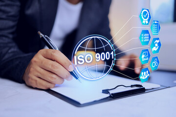 iso 9001 quality management system concept with businessman working on desktop to sign approved document for continue and maintain the quality in product and service in manufacture factory