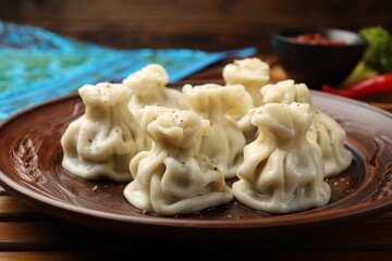 Delicious khinkali served on wooden table, closeup