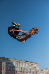 A girl jumps on an outdoor trampoline.