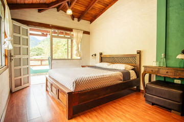 Cozy rustic bedroom with wood bed, vaulted wood ceiling, large windows and mountain view. Perfect...