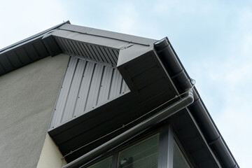 Fototapeta premium View of a contemporary building highlighting a sharp roofline, metallic siding, and large windows, showcasing modern architecture against a clear sky