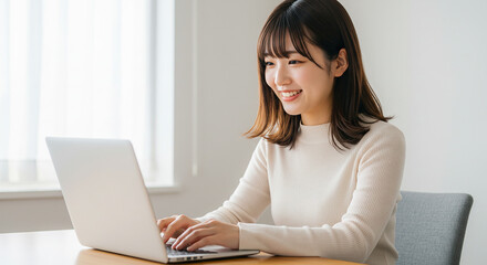 ノートパソコンを操作する若い女性の笑顔