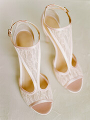Elegant lace high-heeled sandals displayed on a neutral background for a fashion showcase