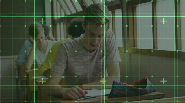 Teenage male student placing red pen and starting exam writing after green grid overlay settling