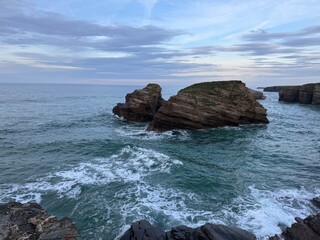 Cathedrals beach during high tide, Ribadeo, Spain. The whole beach and the bottom of stairs all covered with deep water, waves splashing against the rocks
