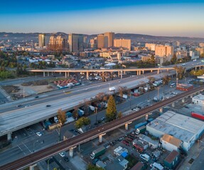 Aerial view of Oakland, California, USA, showcasing the city skyline, highway traffic, and railway...
