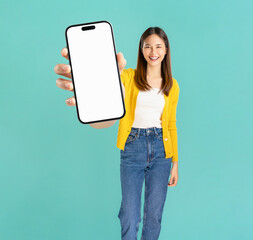 Portrait of confident Asian business woman casual yellow shirt and holding big smartphone mockup of blank screen and smiling on blue background.
