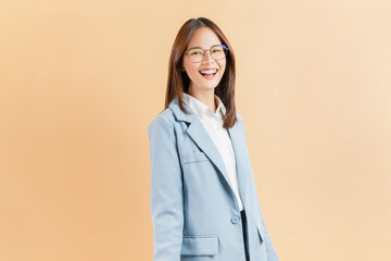Smiling Asian businesswoman standing isolated against a beige background.