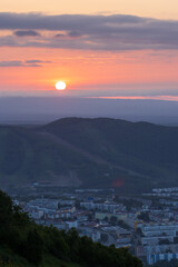 Morning cityscape. Top view of the buildings among the hills. Residential urban areas at sunrise. The sun rises over the mountains. City of Petropavlovsk-Kamchatsky, Kamchatka Krai, Far East of Russia