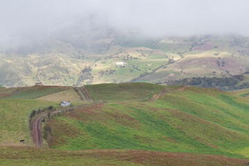 rural path with green colombian countryside mountains landscape and grey clouds at background