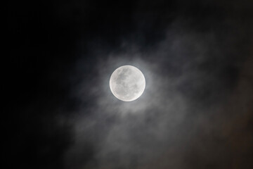shiny full moon with clouds and mist in middle of the night