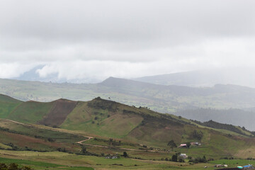 Colombian countryside grass mountains with rainy clouds and crops