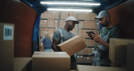 Outside of Logistics Retail Warehouse: Diverse Employees Unloading Delivery Truck with Cardboard Boxes. Manager Scanning Parcels Using Digital Tablet. Online Orders, Purchases and E-Commerce Goods. - Powered by Adobe