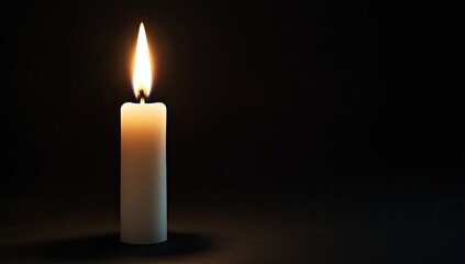 Single candle flame against a dark background