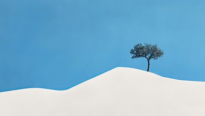 Solitary tree atop a snow-capped hill against a vibrant blue sky