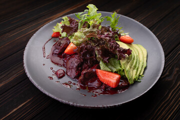 Warm liver salad with avocado, strawberry, and greens