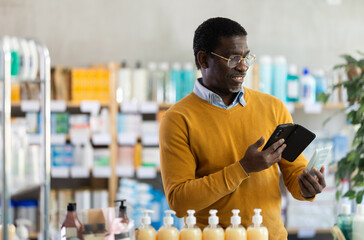Male buyer scans code on package of skin cream to check the expiration date