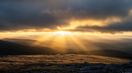 Golden sunrise breaking through dark clouds over mountain range