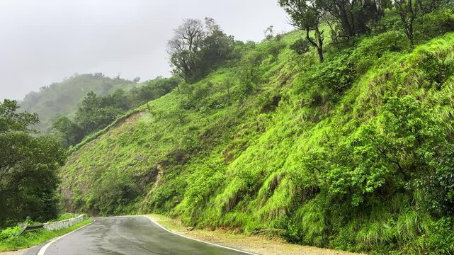Scenic road through winding mountain road surrounded by rainy tropical forest in charmadi karnataka india