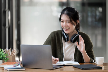 Hipster teen girl school student wear headphone watch video online webinar learn on laptop elearning course video conference pc call in library