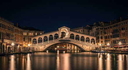 Obraz premium Majestic Rialto Bridge Illuminated at Night Over the Grand Canal in Venice