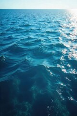 Obraz premium Vast expanse of deep blue ocean water, sunlit surface reflecting light, gentle waves, tranquil scene, pristine marine environment , coast, sunbeams, underwater