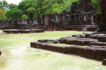 Ancient architecture set in a lush summer landscape with stone walkways and trees.