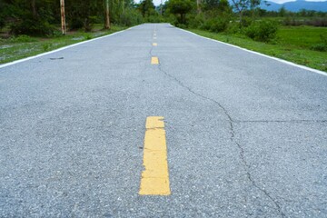 Yellow lines mark the rural asphalt road, a solitary route stretching through the landscape