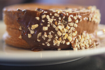 Delicious pastry topped with chocolate and nuts on a plate