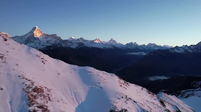 Cinematic Drone Footage of a Snowy Mountain Range at Sunset